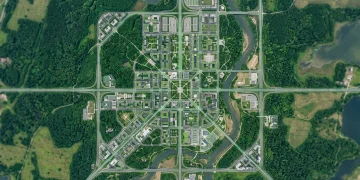 Aerial view of an interconnected urban and natural landscape, illustrating global trends shaping daily life with green architecture and glowing pathways.