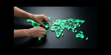 A person's hands arranging glowing green geometric shapes on a matte black surface, forming a network symbolizing global cultural trends.